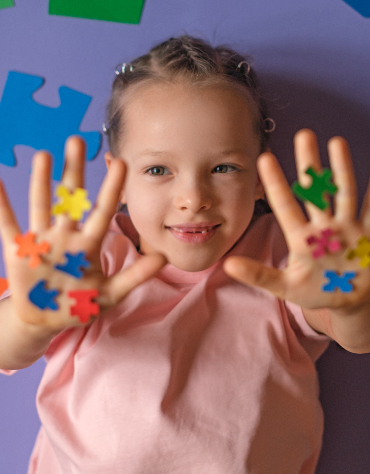 young child holding up puzzle pieces