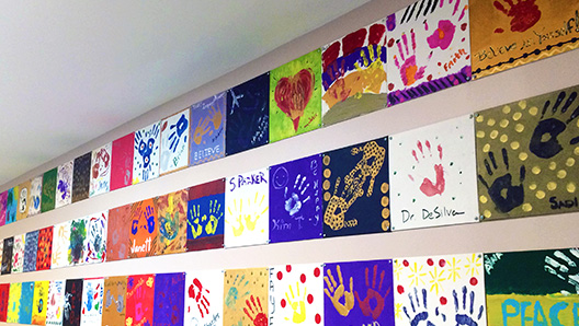 Wall of paintings with children hand prints